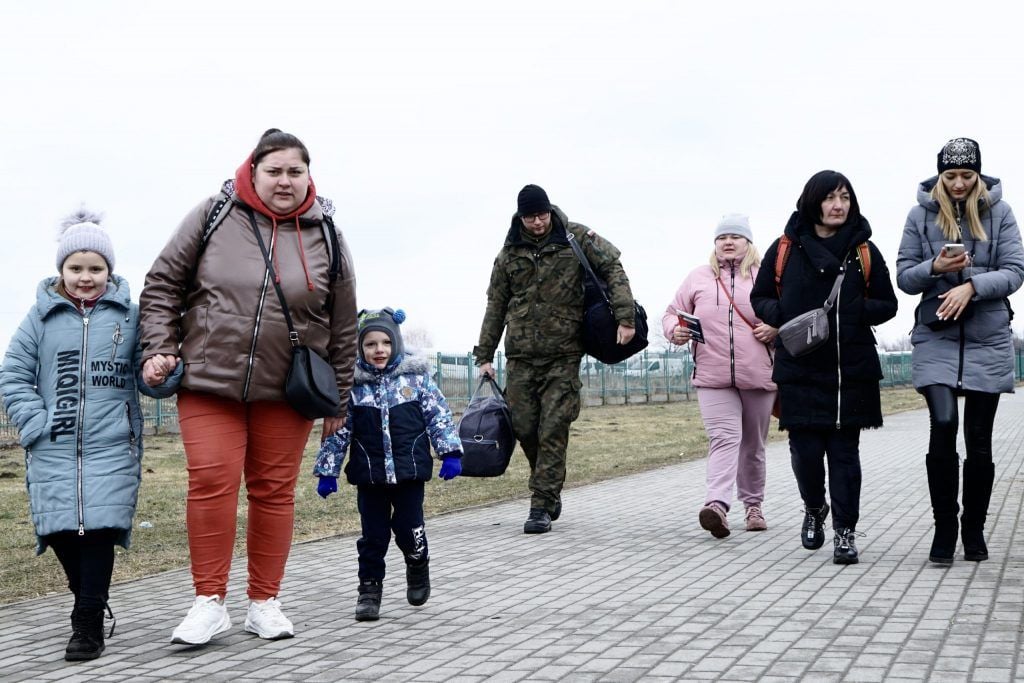 Una familia que llega y es ayudada por un oficial de frontera. Medyka, 9 de marzo de 2022. / Foto: Alejandro Taquechel